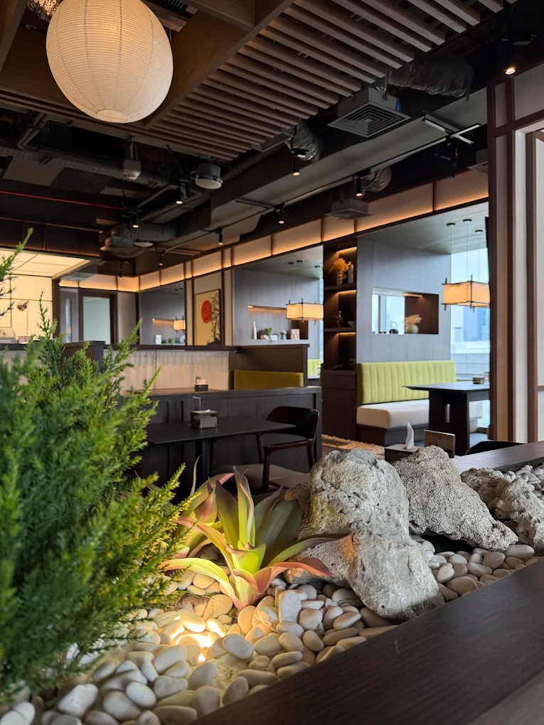 Zen pebble garden, rocks, and greenery inside JINSEI